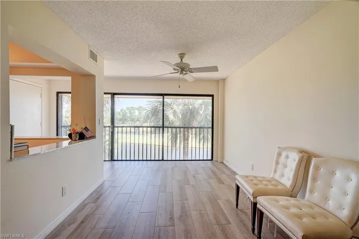 Sitting room featuring ceiling fan, a textured ceiling, and light wood-type flooring