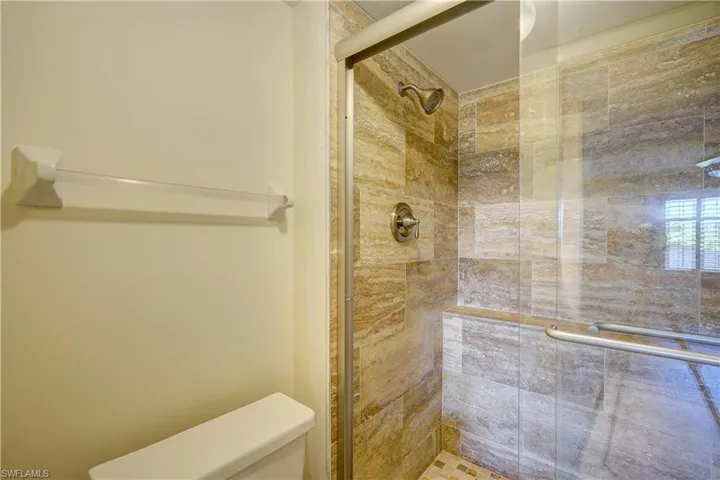 Bathroom featuring a tile shower and toilet