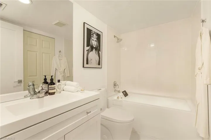 Bathroom with shower / bathing tub combination, visible vents, toilet, and vanity