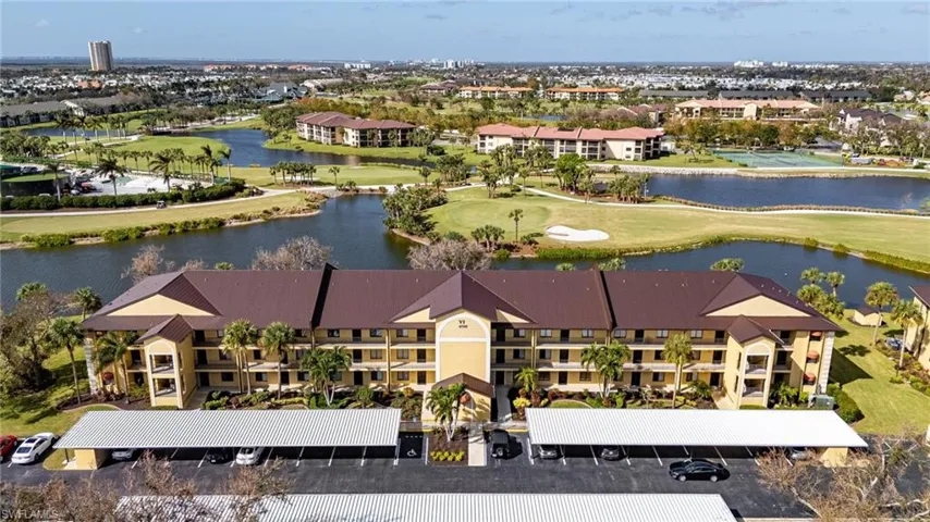 Drone / aerial view with golf course view, a water view, and a residential view