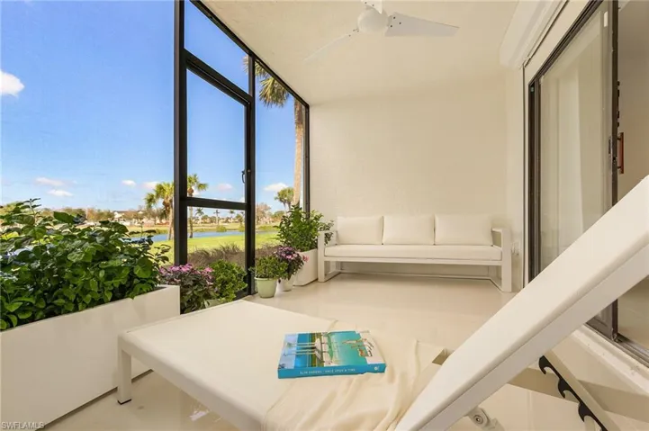Sunroom / solarium featuring a ceiling fan and a water view