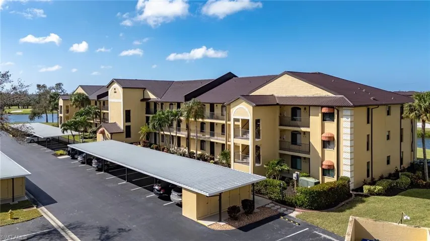 View of building exterior with uncovered parking and a residential view