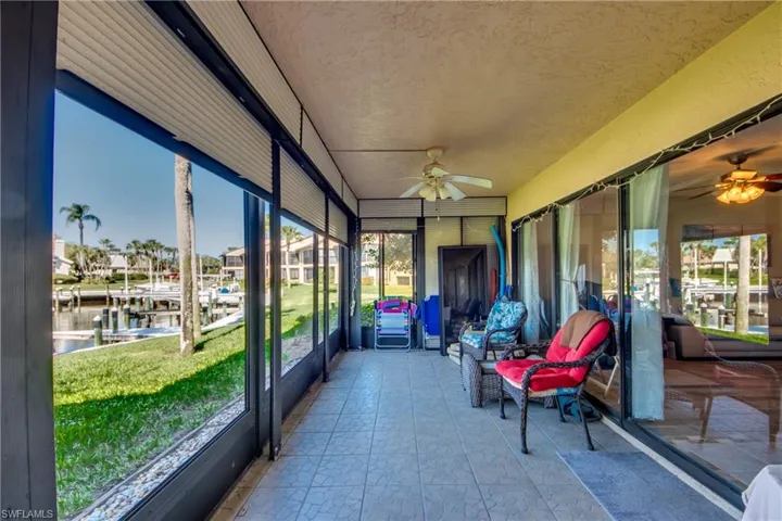 Sunroom featuring ceiling fan, a water view, and healthy amount of natural light
