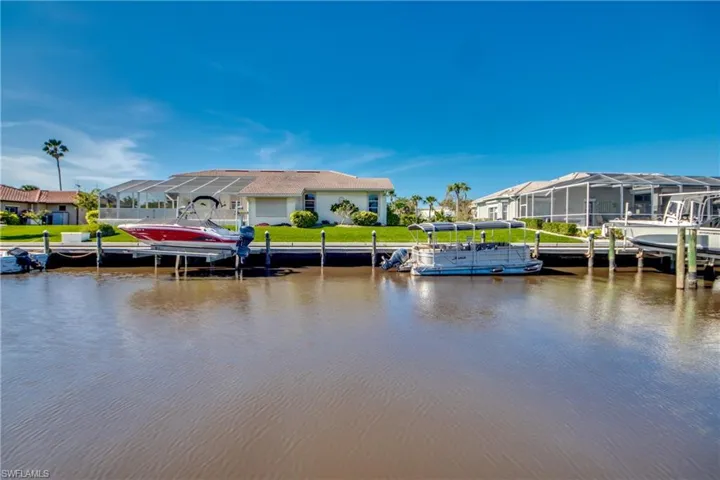Dock area featuring boat lift, a water view, and a residential view
