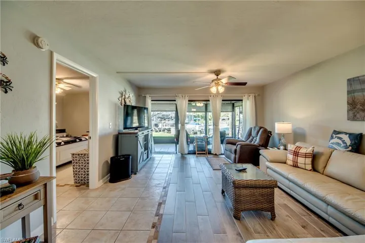 Living area with ceiling fan and light wood-style flooring