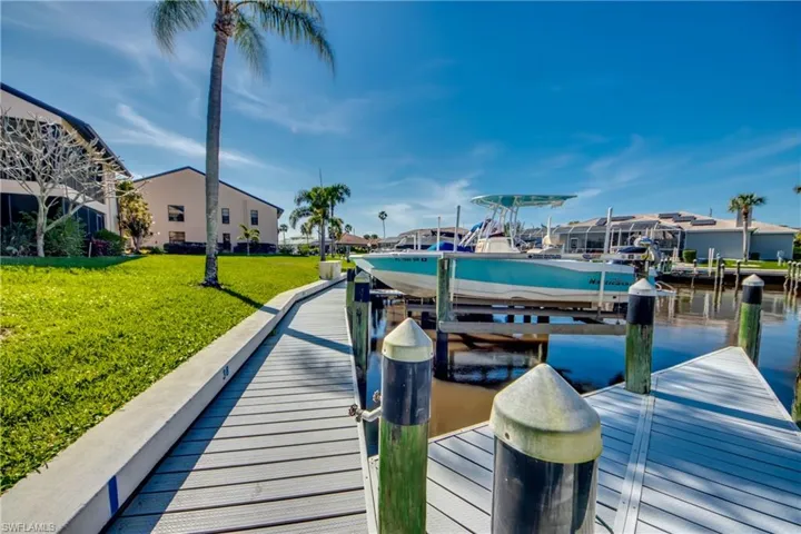 Dock featuring a water view, boat lift, and a yard