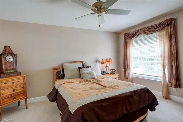 Carpeted Guest bedroom featuring ceiling fan