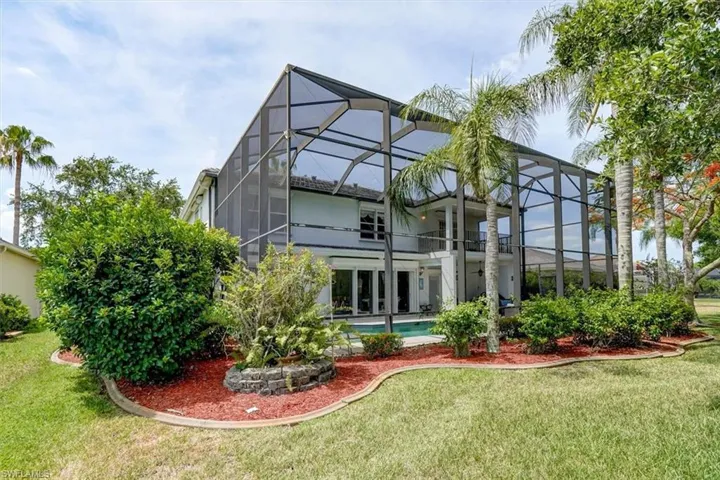 Rear view of house featuring a lanai and a yard