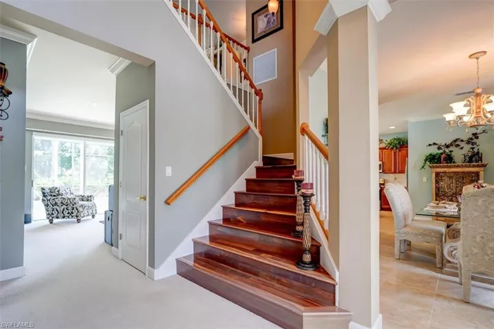 Stairs with crown molding, carpet flooring, and a chandelier