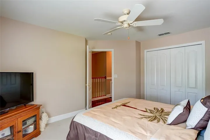 Carpeted Guest bedroom featuring a closet and ceiling fan