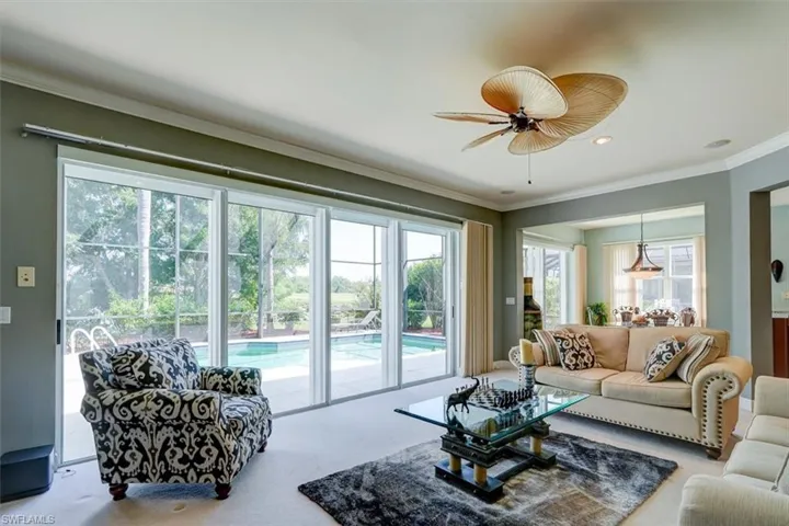 Great room featuring ornamental molding, carpet flooring, and ceiling fan