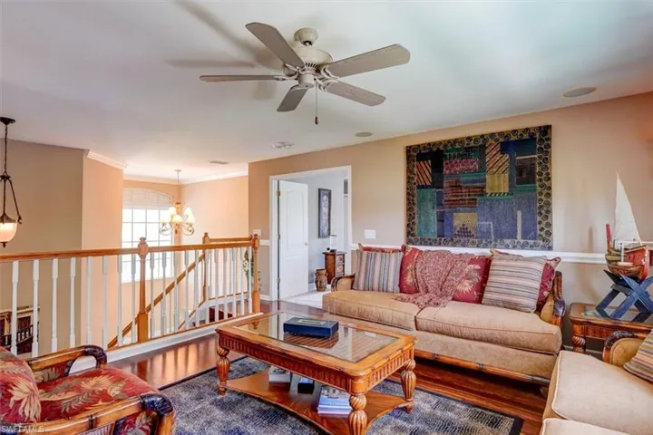 2nd Floor Living room with hardwood / wood-style floors, ornamental molding, and ceiling fan with notable chandelier