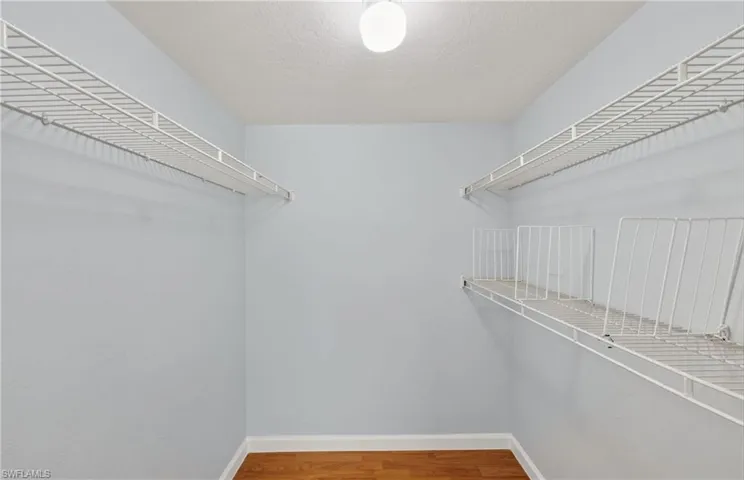 Walk in closet with light wood-style floors