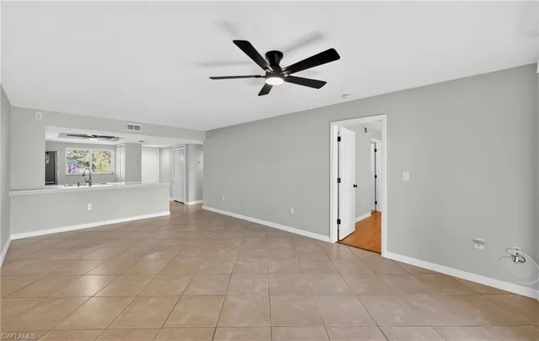 Empty room featuring ceiling fan and light tile patterned floors