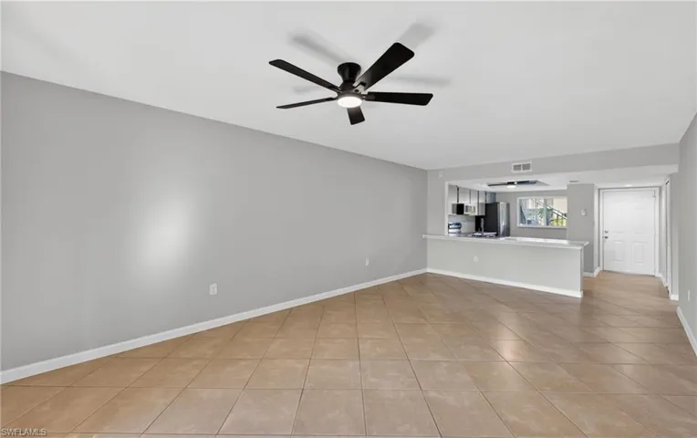 Unfurnished living room featuring ceiling fan and light tile patterned flooring