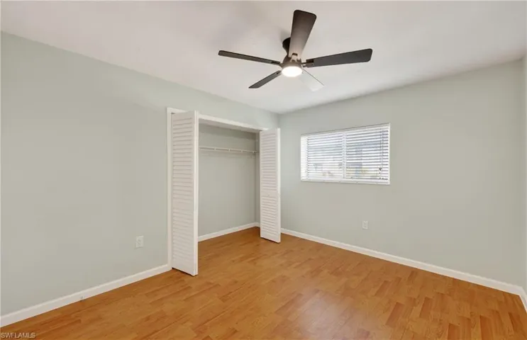 Unfurnished bedroom with light wood-style floors, a ceiling fan, and a closet
