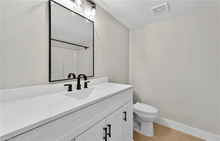 Full bathroom with vanity, a shower with shower curtain, and light tile patterned floors