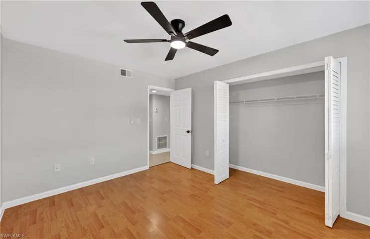 Unfurnished bedroom featuring light wood-style flooring, a closet, and ceiling fan