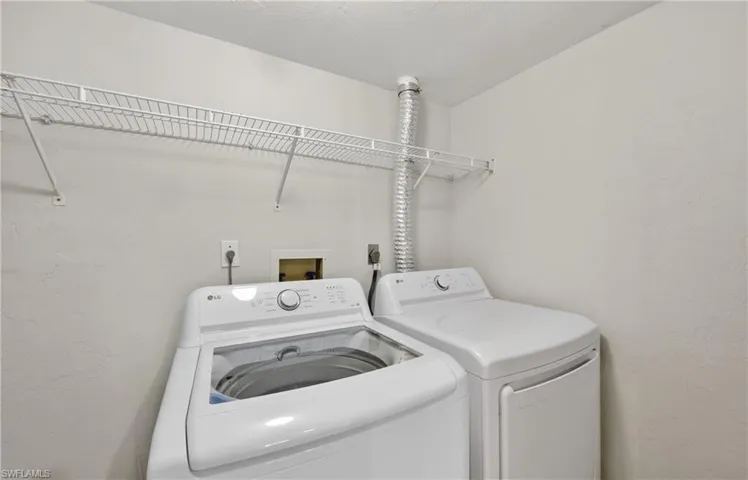 Laundry area with a textured wall and washing machine and dryer