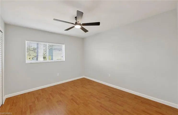 Empty room with wood finished floors and a ceiling fan