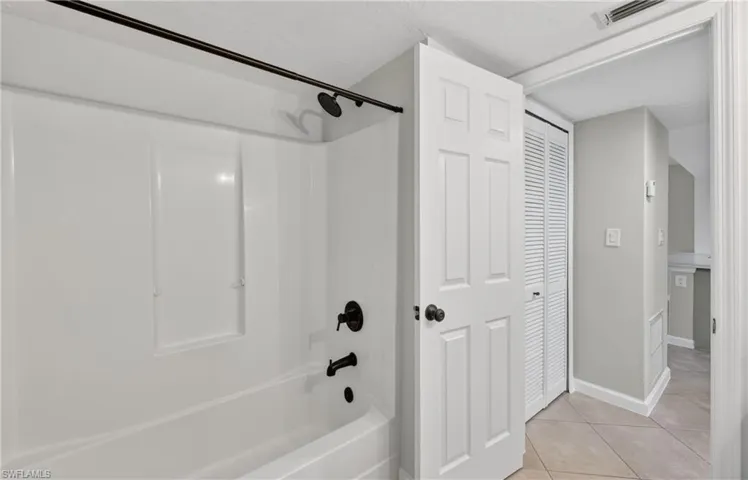 Full bath with shower / bathtub combination, a closet, and light tile patterned floors