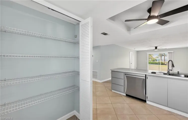 Kitchen with ceiling fan, dishwasher, light tile patterned floors, and light countertops