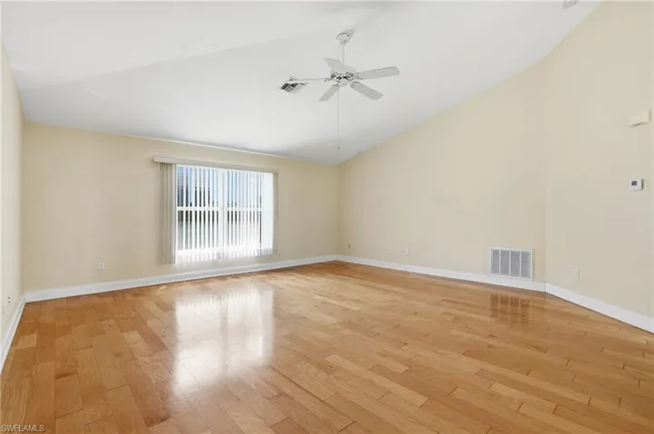 Spare room with lofted ceiling, light wood-style flooring, and ceiling fan