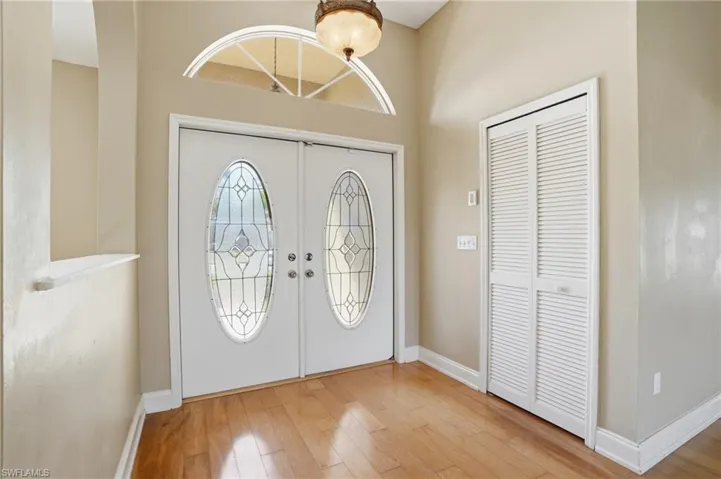 Foyer entrance with light wood-type flooring and french doors