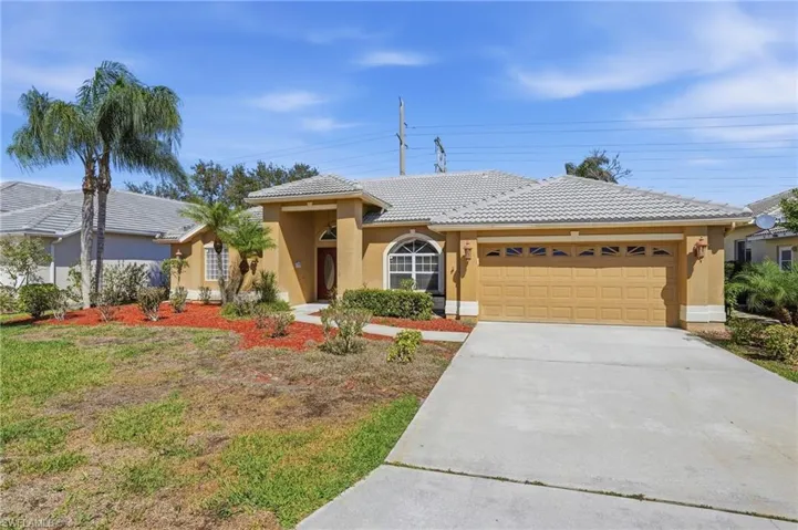 View of front facade featuring a garage, stucco siding, concrete driveway, and a tile roof