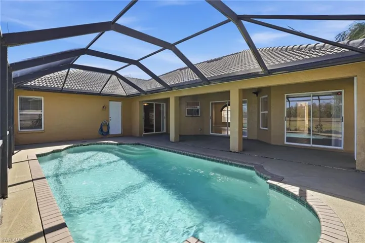 Outdoor pool featuring a patio area, a sunroom, and a lanai