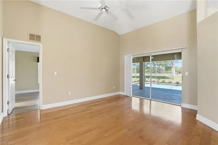 Empty room with ceiling fan, light wood-style floors, and lofted ceiling
