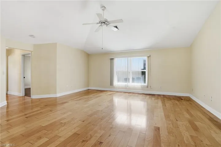 Unfurnished room with vaulted ceiling, ceiling fan, and light wood finished floors