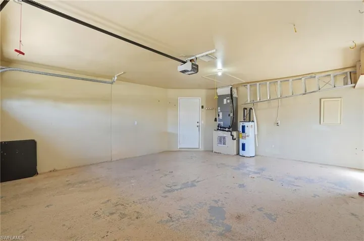 Garage with heating unit, water heater, and a garage door opener