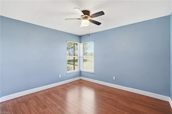 Empty room with wood finished floors and a ceiling fan