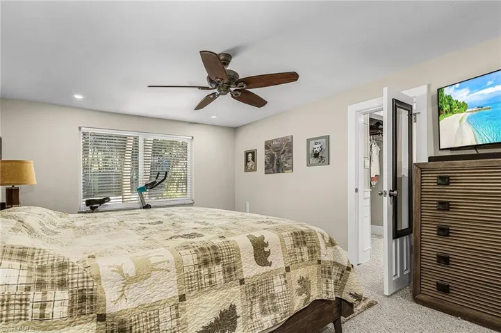 Bedroom with light colored carpet, ceiling fan, and recessed lighting