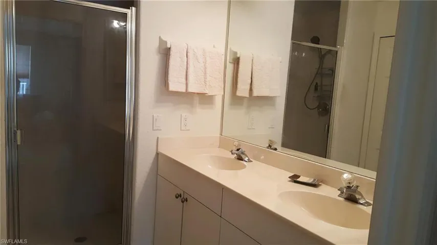 Full bath with a shower stall and double vanity