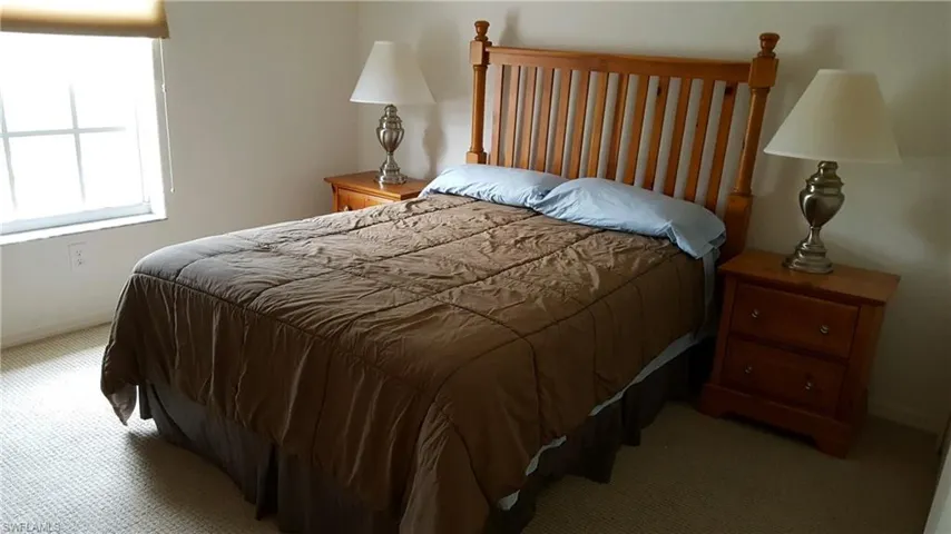 Bedroom featuring light colored carpet and baseboards
