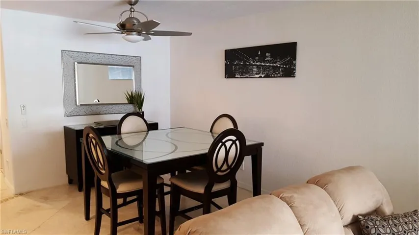 Dining area with a ceiling fan, light tile patterned flooring, and baseboards