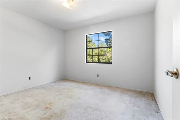 Carpeted empty room featuring a textured ceiling and baseboards