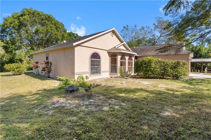 View of property exterior with stucco siding and a yard
