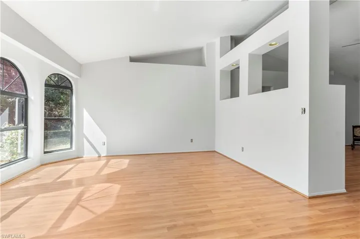 Unfurnished room featuring lofted ceiling and light wood finished floors