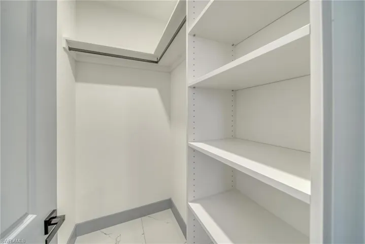 Walk in closet featuring marble finish floor