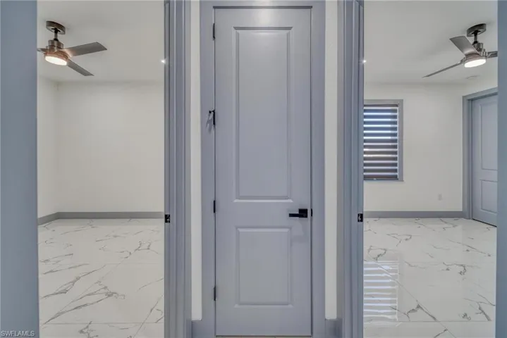 Hall with marble finish floor and baseboards