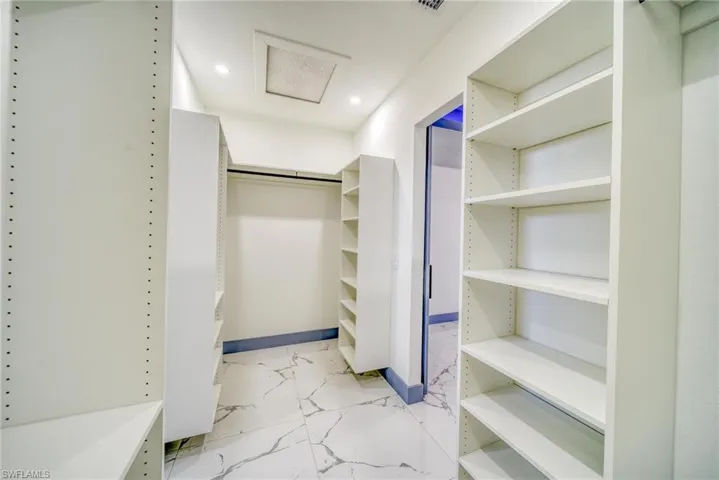 Spacious closet with visible vents, marble finish floor, and attic access