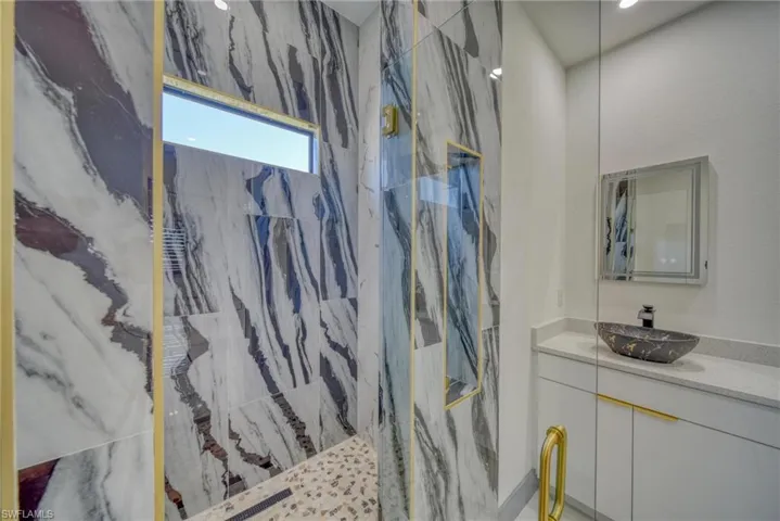 Full bath with vanity and a marble finish shower