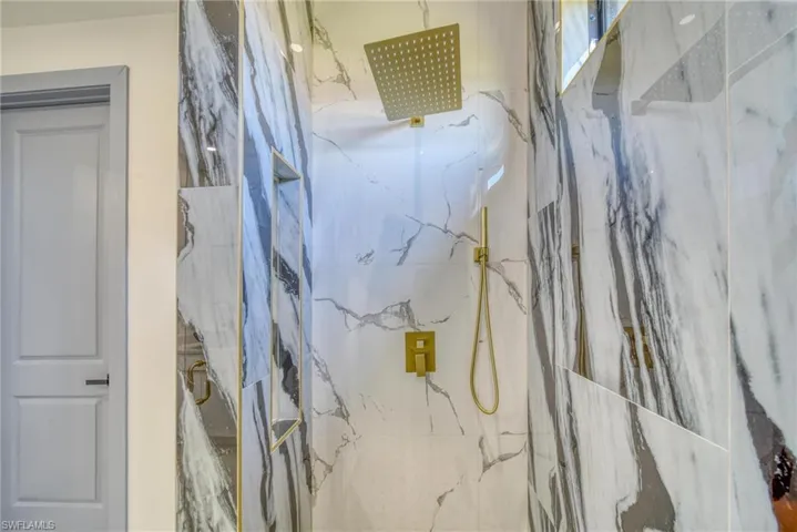 Full bath featuring a marble finish shower