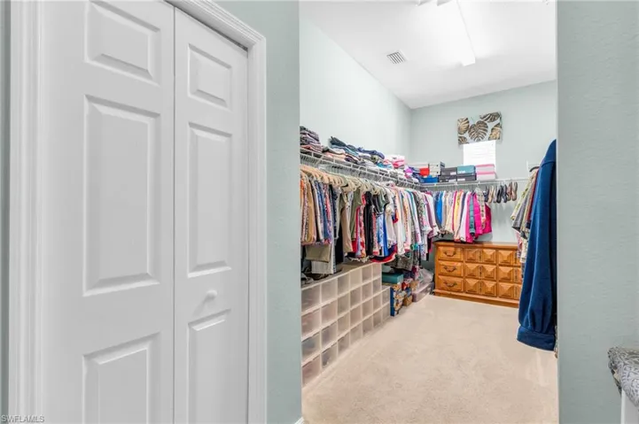 Spacious closet with light colored carpet