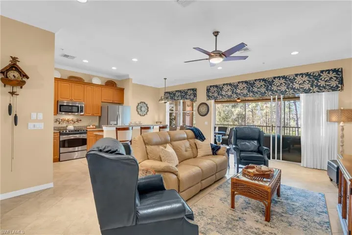 Living area featuring light tile patterned floors, recessed lighting, ceiling fan, and crown molding