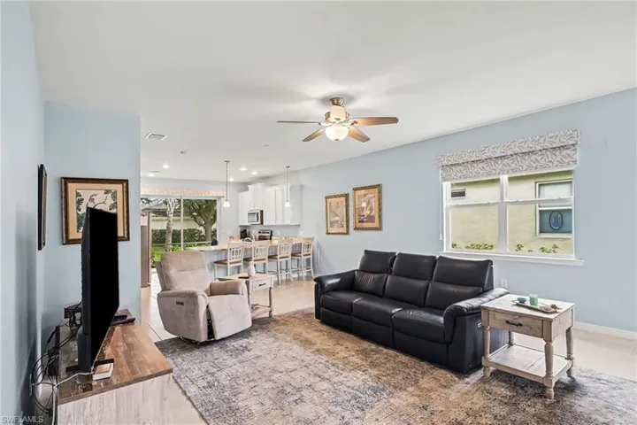 Open-concept living area with tile flooring and a ceiling fan