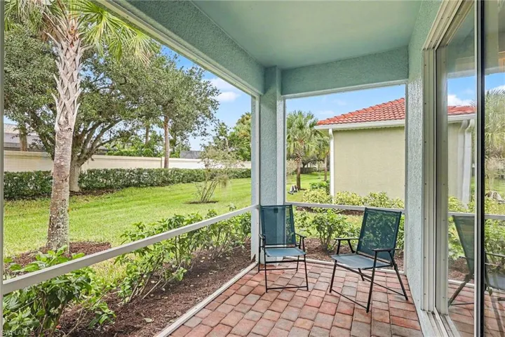 Screened patio with brick paver flooring and lush landscaping